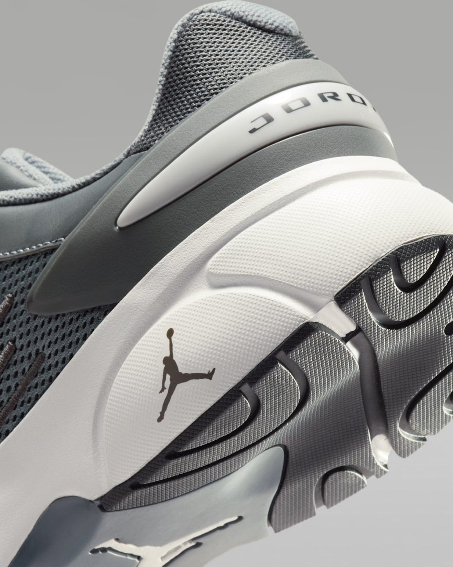 Close-up of grey and white sneaker heel showing embossed Jordan wordmark and Jumpman logo