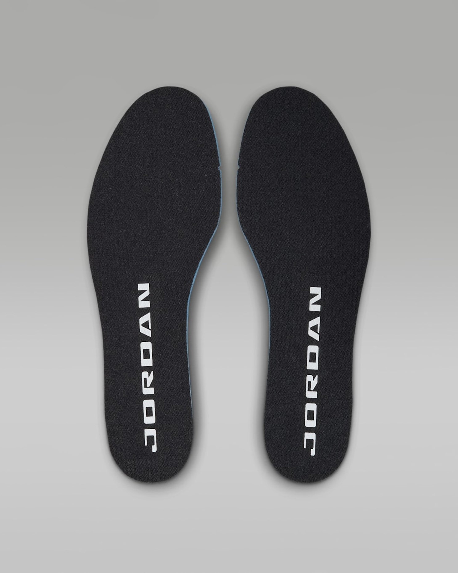 Pair of black sneaker insoles with white Jordan wordmark printed vertically