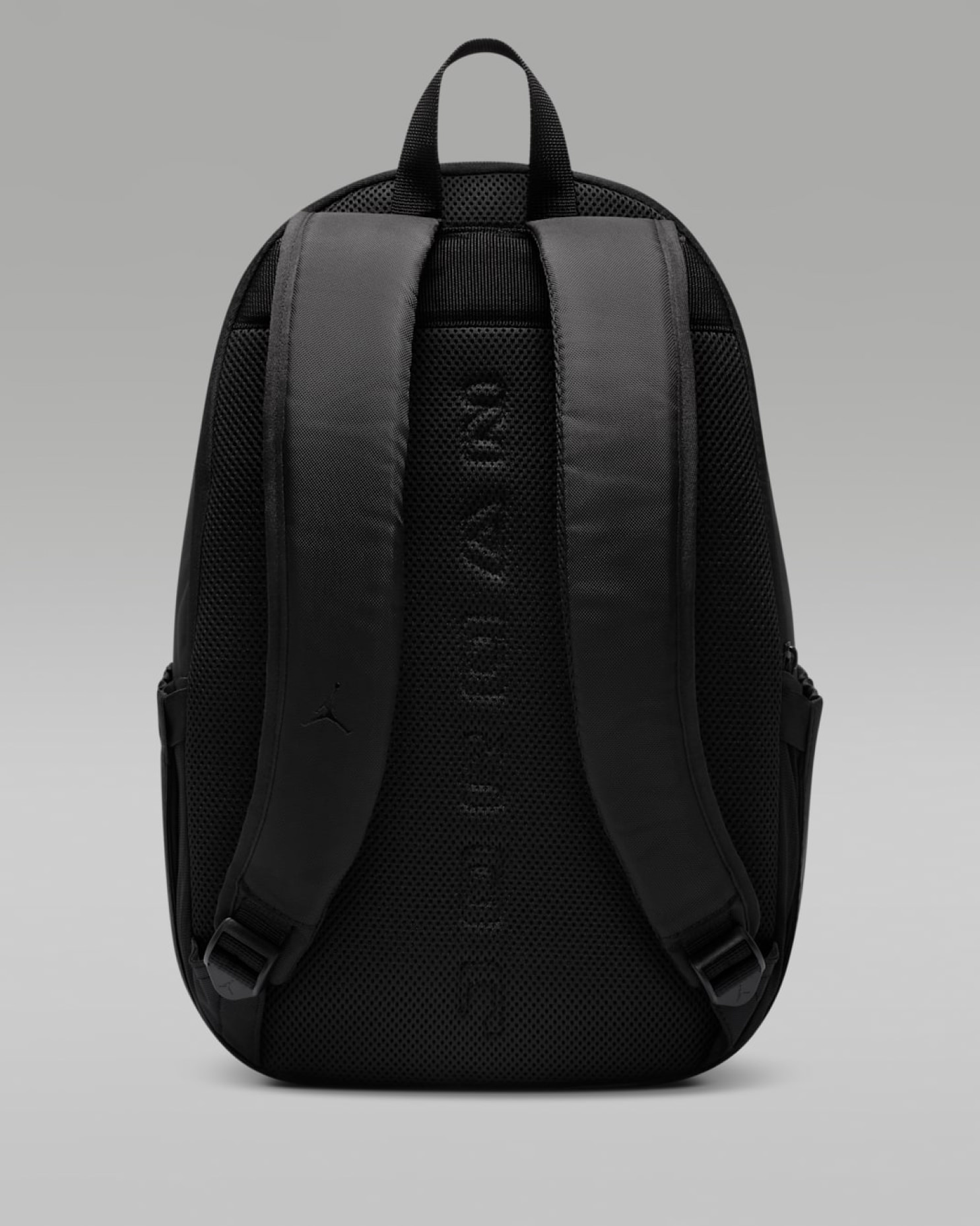 Rear view of black Jordan backpack showing padded straps, mesh back panel, and tonal embossed lettering with Jumpman logo
